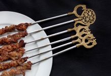 Grilled meat on skewers with ethnic symbols on handles (© Deb Lindsey/Washington Post/Getty Images)