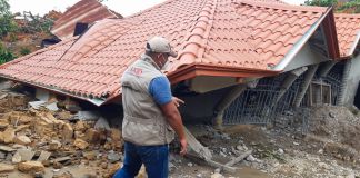 Un hombre camina junto a una casa destruida (USAID)