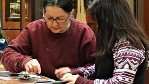 A cultural educator working with a child on an art project