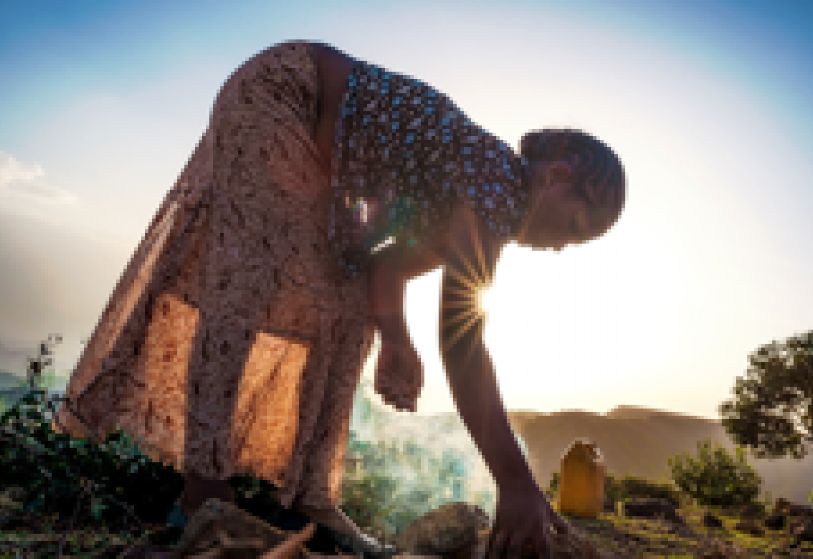 Young woman bending down to tending to her outside chores 