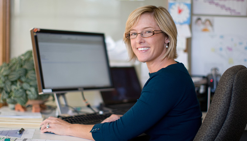 Picture of a woman sitting in front of a computer monitor