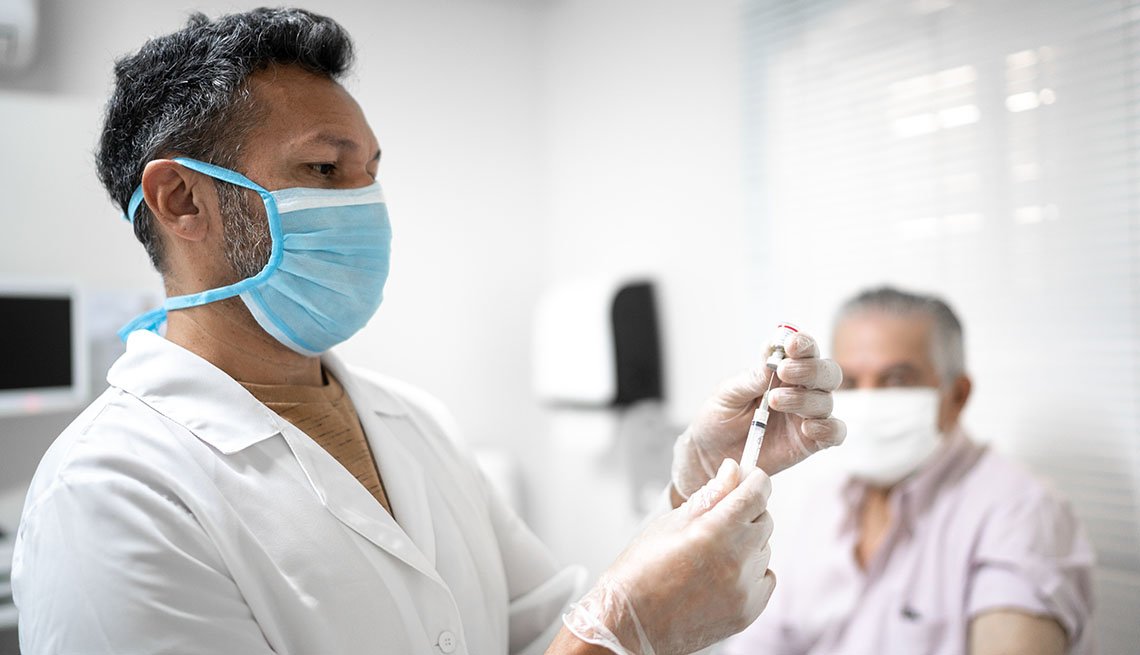 medical provider preparing vaccine with patient in background