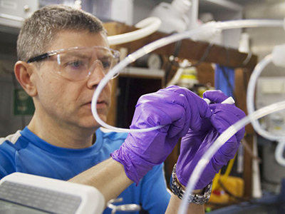 Dr. Antonio Mannino installs a Coulometer in the on-board wet lab to measure particle productivity in water samples. Credit: Monika Naranjo Gonzalez (SOI)