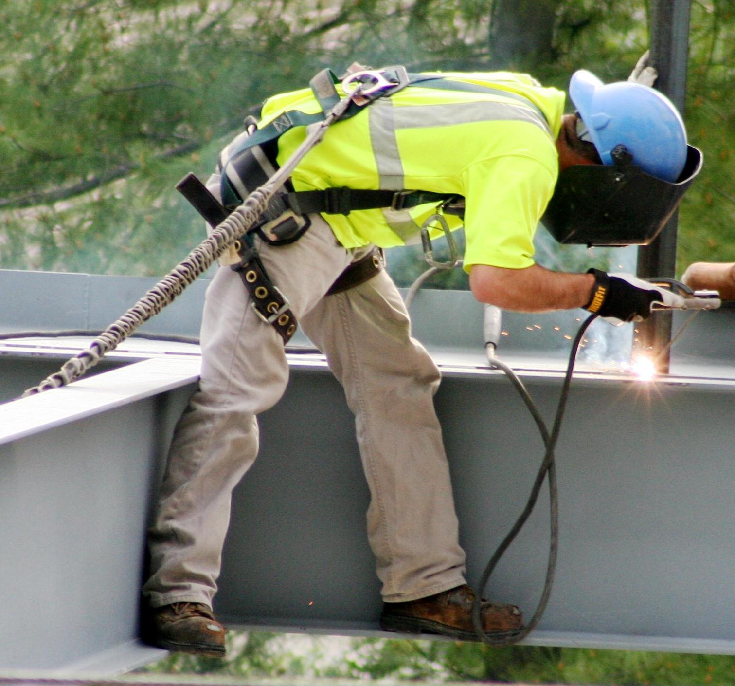 Construction worker using a tool to work on a building