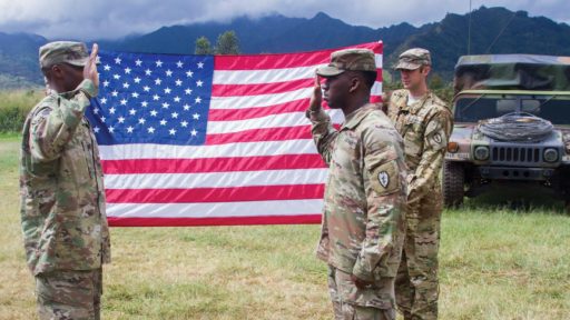 Service Member Reenlists in front of a Flag