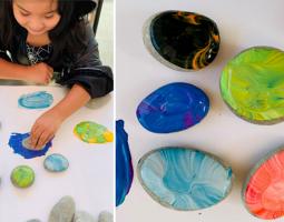 Child doing a colorful art project with paint and rocks