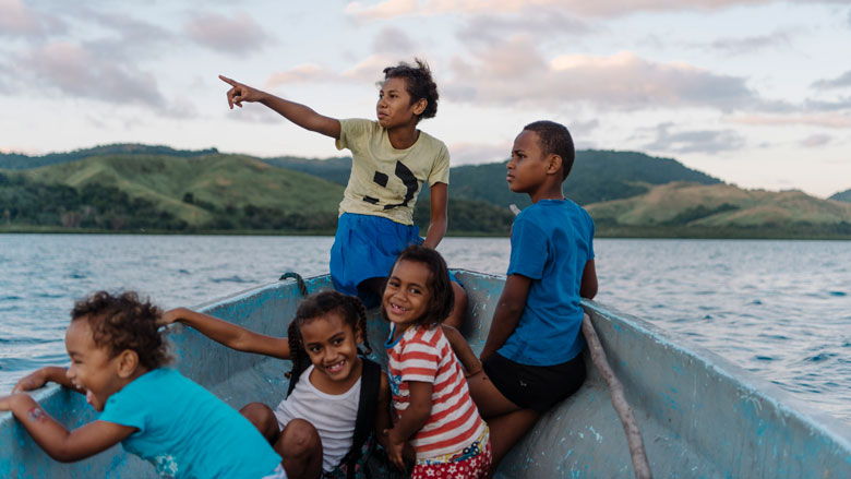 أطفال من فوني سافي سافي، فيجي، يجلسون في قارب القرية أثناء سفرهم إلى مكان السباحة المفضل لديهم، وهو حفرة عميقة في الشعاب المرجانية تسمى 