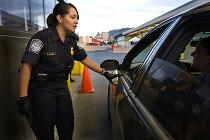 A CBP Officer inspects a vehicle and passengers at a land border port of entry