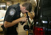 CBP officer inspects fuel tank of a vehicle