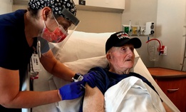 World War II veteran John Mohun, 94, receives the Pfizer-BioNTech COVID-19 vaccine at a Veterans Affairs facility in Phoenix on Tuesday.