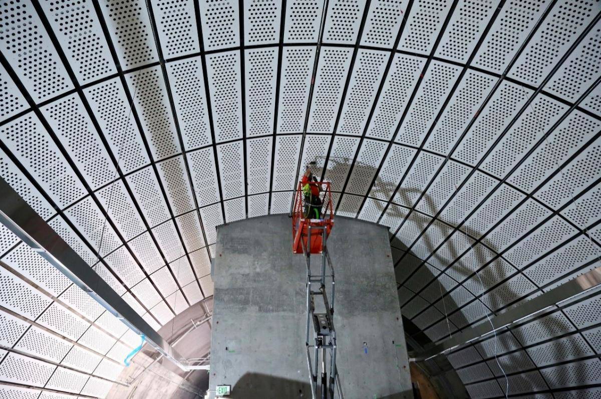 SFMTA workers install some of the final decorative panels at the platform level in Chinatown–Rose Pak Station on the new Central Subway line, which is projected to open for service in 2022. (Courtesy SFMTA)