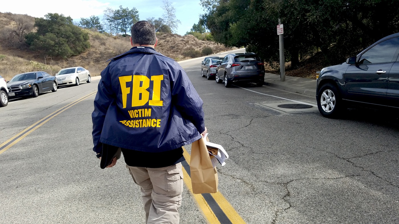 A Victim Services Response Team member carries a bag of personal effects from the incident site of a mass shooting in Thousand Oaks, California in November 2018.
