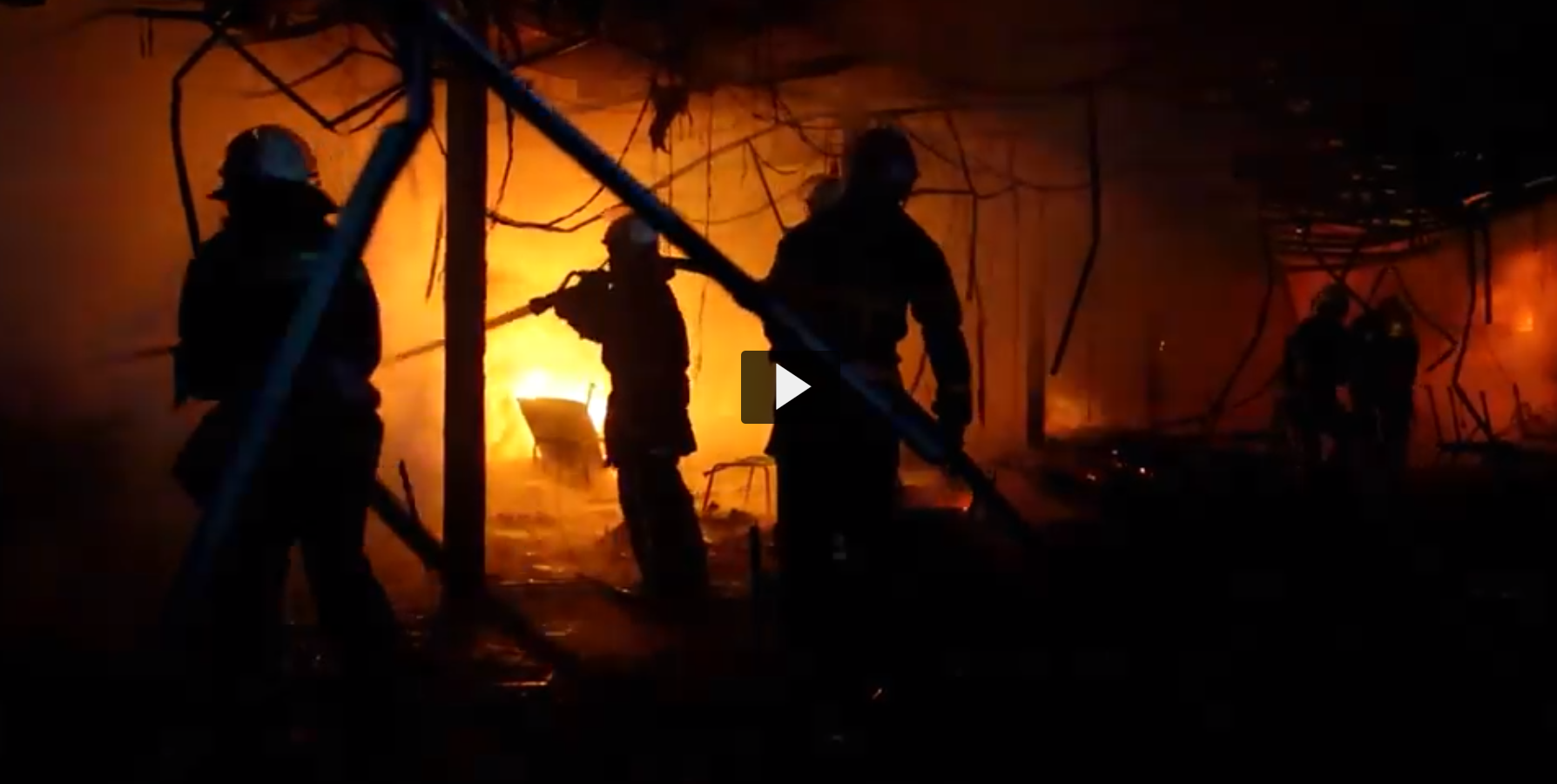 Screenshot of a video in which we see a silhouette of firefighters responding to a burning fire