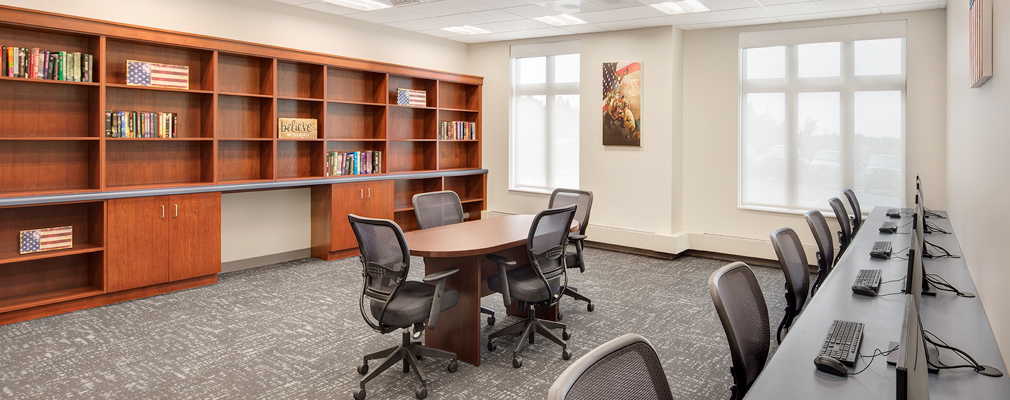 Photograph of a business center with bookshelves and computer stations.