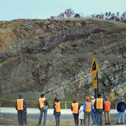 Team of scientists stand in front of outcrop