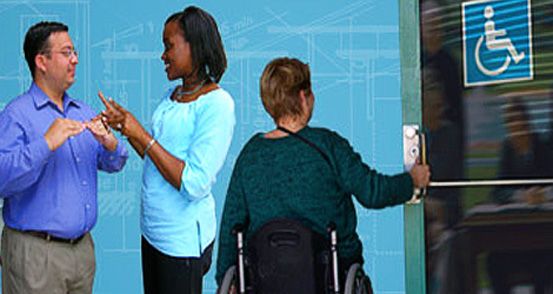 Image showing two people using sign language and a woman using a wheelchair opening a door