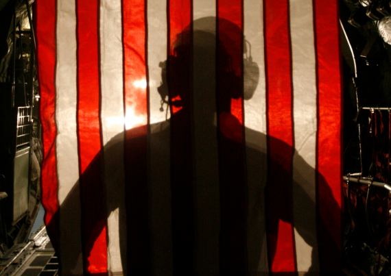 Photo - military serviceman silhouetted against US flag