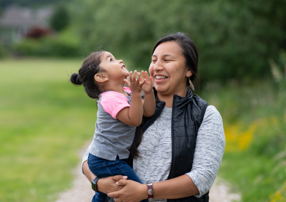 Woman holding little girl in park