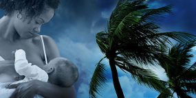 Image of mother breastfeeding her baby over background of palm trees blowing in heavy winds