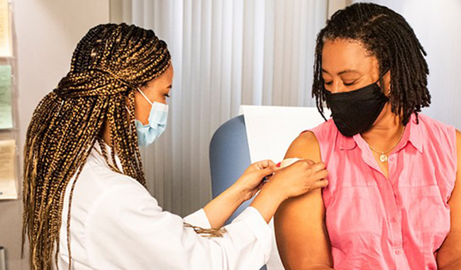 Una enfermera vacunando a un paciente.