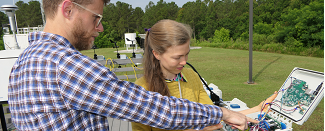 Researchers inspecting air monitor