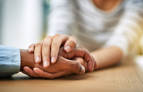 close-up of the hands of two people holding hands