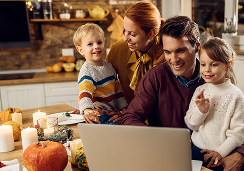 A family sitting together during the holidays while looking at a computer screen