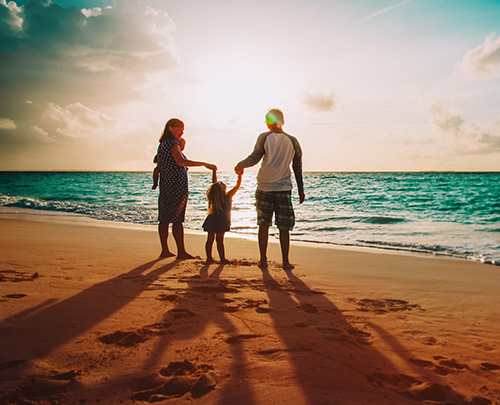 Three people walking on a beach