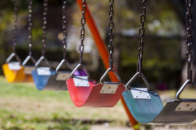 Close up of empty colorful swings at a playground