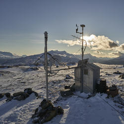 The new radar-based precipitation sensor is on the left, with the anemometer, wind vane, and GOES antenna on the station shack 