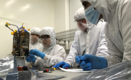 Photo of scientists in lab assembling equipment