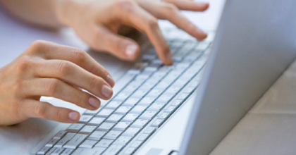 hands typing on a computer keyboard