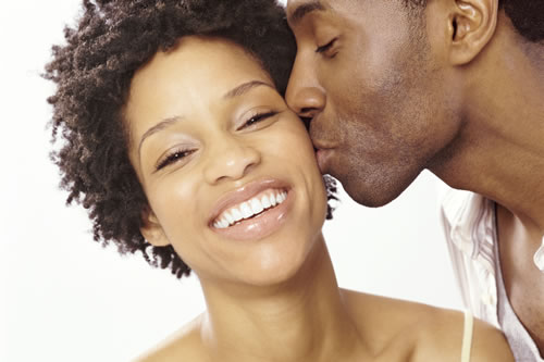 man kissing woman on cheek