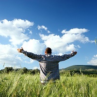 Man in field with arms outstretched