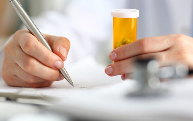 New York and Oklahoma Make it Easier for Persons with Behavioral Health Conditions to Access Non-Nicotine Cessation Medications - photo of a woman's hands holding a prescription bottle and writing notes.