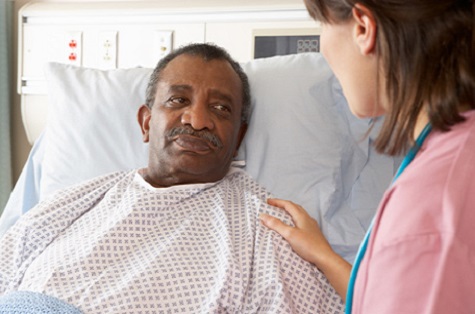 nurse talking to male patient in hospital bed