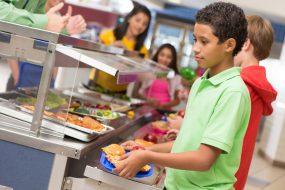 Middle school students getting lunch items in cafeteria line