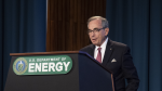 Anthony Cancelosi speaks at a podium, the podium is branded "US Department of Energy."