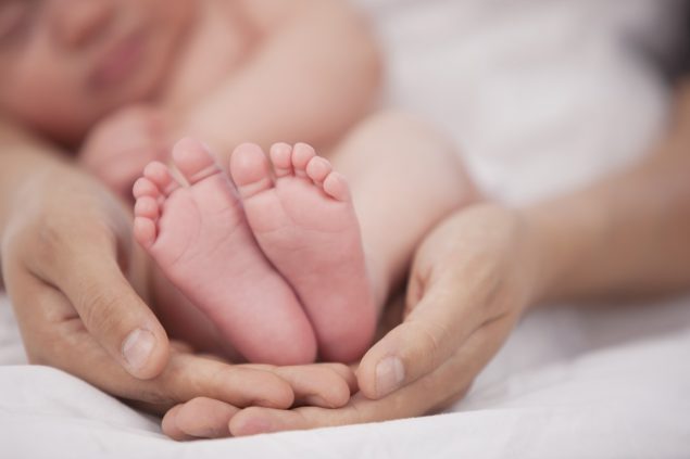 Photo of mother holding infant's feet