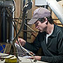 Photo of a weatherization worker conducting a furnace safety check.