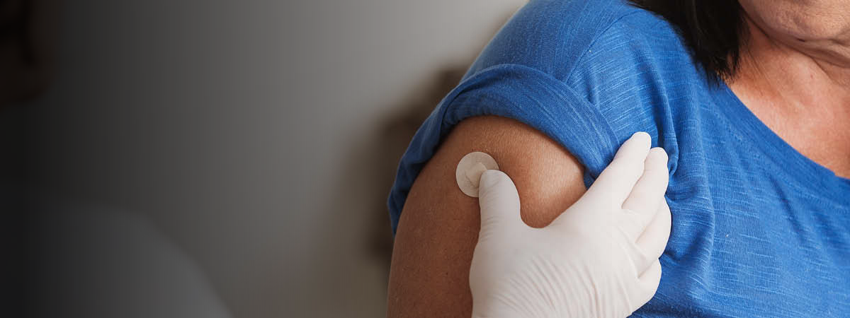 Nurse putting bandaid on a female patient's arm