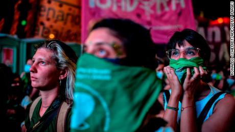 Demonstrators wait with green headscarves -symbol of abortion rights activists- outside the Argentine Congress in Buenos Aires, on December 11, 2020, where a bill to legalize abortion is being discussed in the Chamber of Deputies. - The lower house of Argentina&#39;s parliament approved the legalization of abortion on Friday, sending the proposal to the Senate -- which rejected a similar bill two years ago. (Photo by RONALDO SCHEMIDT / AFP) (Photo by RONALDO SCHEMIDT/AFP via Getty Images)