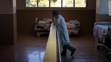 Respiratory therapist Babu Paramban talks on the phone next to hospital beds while taking a break in the COVID-19 unit at Providence Holy Cross Medical Center in the Mission Hills section of Los Angeles, Thursday, Nov. 19, 2020. California is imposing an overnight curfew on most residents as the most populous state tries to head off a surge in coronavirus cases that it fears could tax its health care system, Gov. Gavin Newsom announced Thursday.(AP Photo/Jae C. Hong)