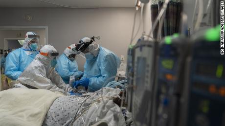 HOUSTON, TX - DECEMBER 22:  (EDITORIAL USE ONLY) Medical staff member Gabriel Cervera Rodriguez (2L) and Dr. Joseph Varon (R) work  to install a medical tube for IV on a patient&#39;s wrist in the COVID-19 intensive care unit (ICU) at the United Memorial Medical Center on December 22, 2020 in Houston, Texas. According to reports, Texas has reached over 1,610,000 cases, including over 26,190 deaths. (Photo by Go Nakamura/Getty Images)