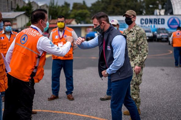 Two men in masks do the COVID-19 fist bump