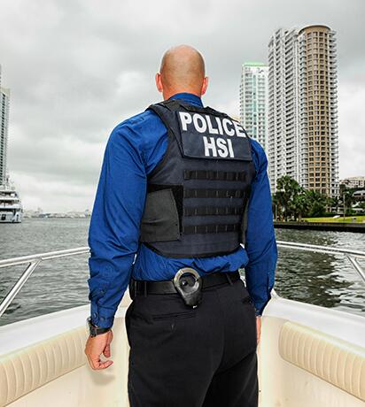 HSI Agent at bow of boat on river