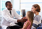 Doctor examining girl's throat