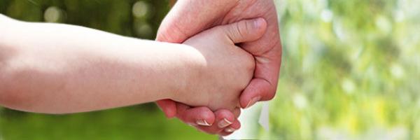 adult holding child's hand