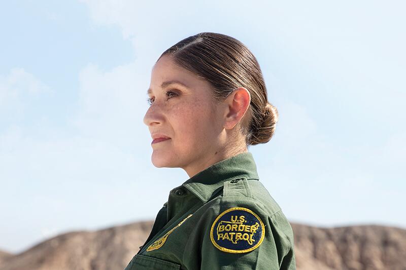 Female Border Patrol agent standing in the desert