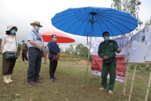 A MAG survey team leader briefs Ambassador Haymond on the current task. (Photo courtesy of U.S. Embassy Vientiane)